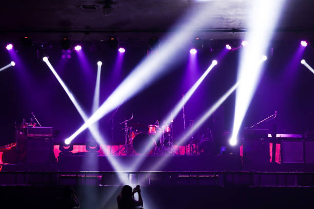 Colorful glow bright spotlights with smoke on stage in dark background, stage concert and music festival show concept.